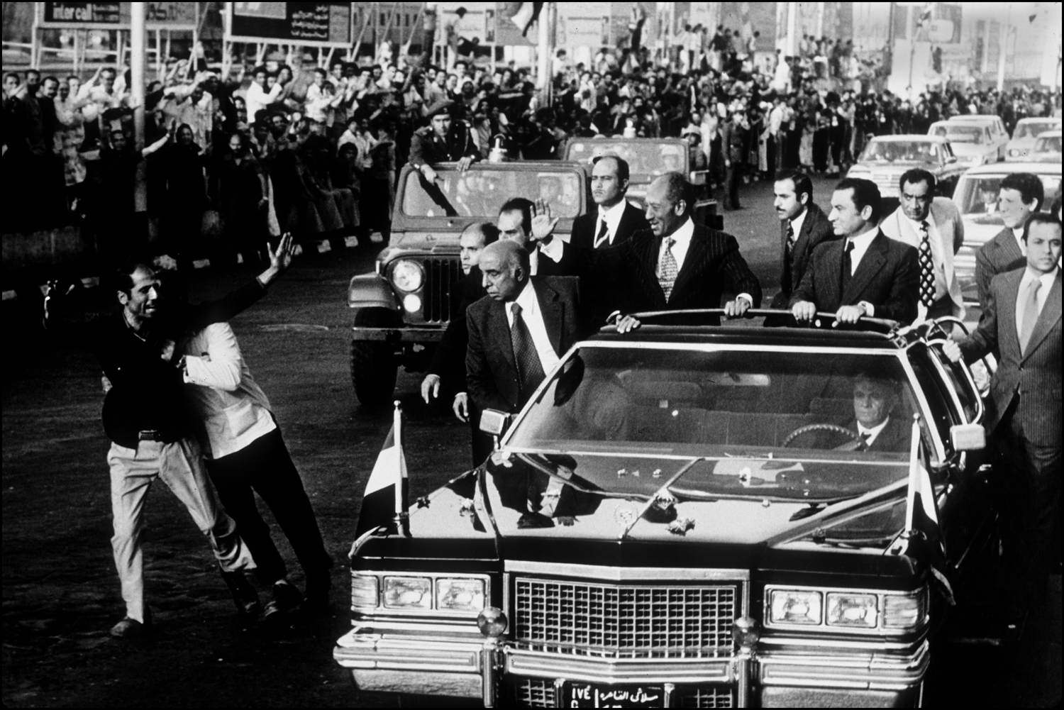 Egyptian President Anwar Sadat waves from his limousine as motorcade drives into Cairo from the airport. Sadat was returning from Washington, DC. : Sadat-Mubarak 1978-1981 : BILL FOLEY 
