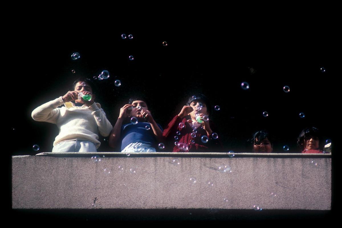 Bubbles, kids in West Beirut blow soap bubbles on their balcony. 1985 : Lebanon 1981-2008 : BILL FOLEY 