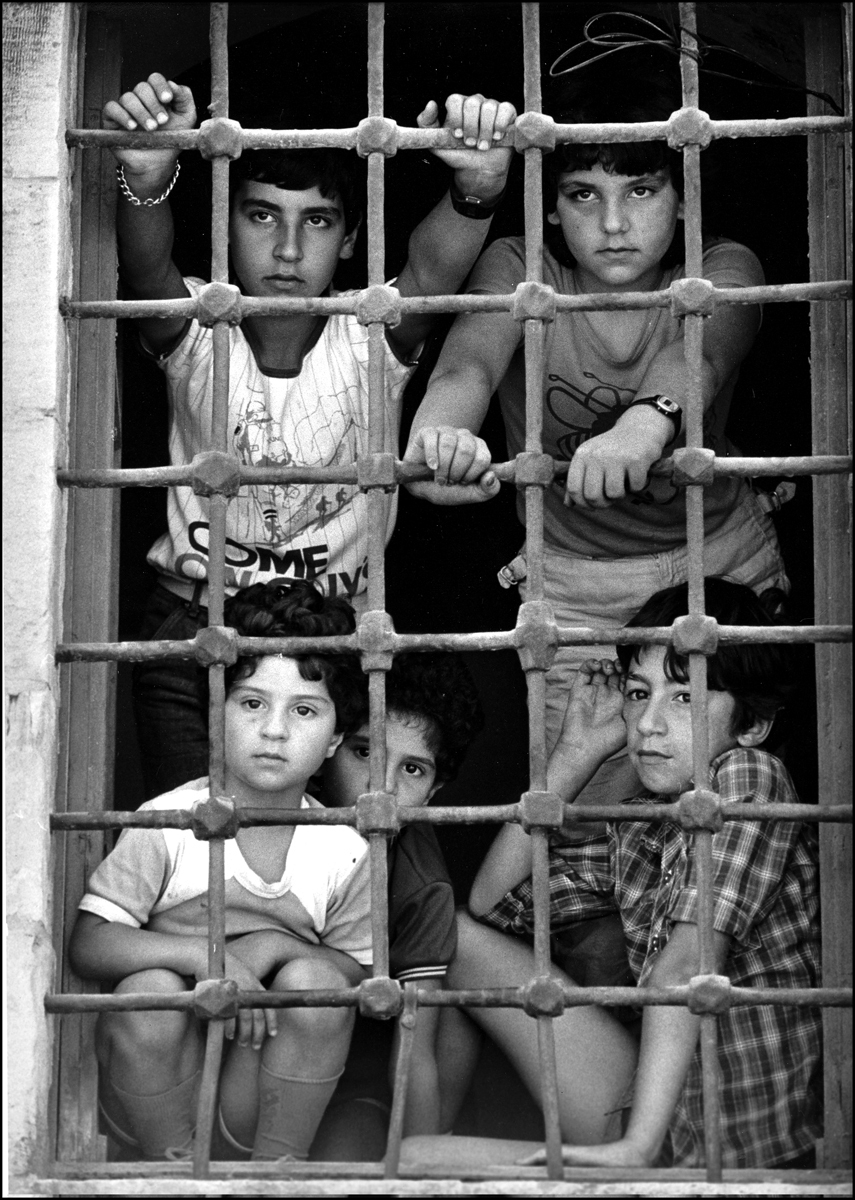 Refuge, Christian kids look out window of a church in Deir el Khamar, watching supplies being delivered during Chouf War. : Lebanon 1981-2008 : BILL FOLEY 