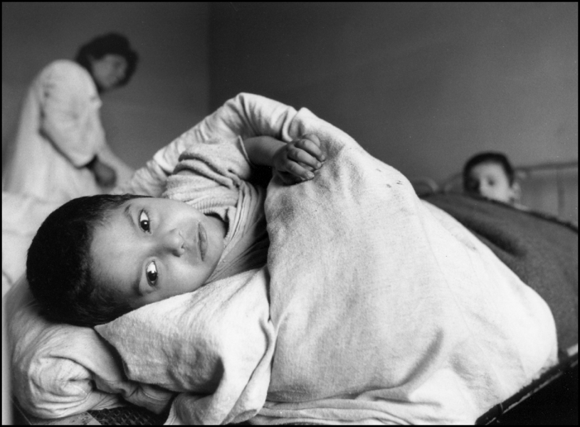 Child looks from his bed as nurse and other kid looks on. 1992 : Albania 1992 : BILL FOLEY 