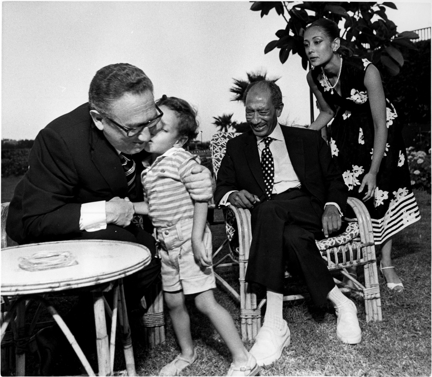 Egyptian President Anwar Sadat smiles as his grandson gives former US Secretary of State Henry Kissinger a kiss. Sadat's rest house, Alexandria, Egypt. : Sadat-Mubarak 1978-1981 : BILL FOLEY 