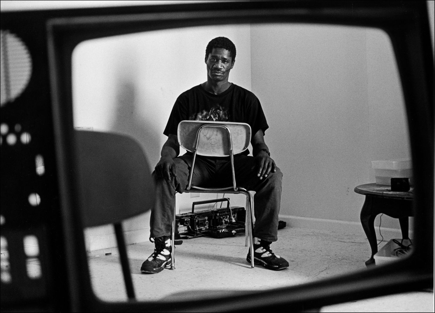 Robert in his living room. He salvages items and resells them. : Carmel Hill Harlem NYC 1995-2000 : BILL FOLEY 