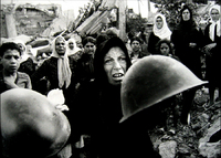 Palestinian woman, holds out helmets found in the Sabra-Chatilla camp after massacre, telling reporters these were worn by the killers. - © 2023 Bill Foley. All Rights Reserved.