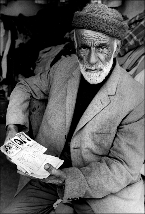 Survivor holds id cards with photographs of relatives murdered 1982 Sabra. : Sabra Chatilla Massacre Beirut 1982 Pulitzer series : BILL FOLEY 