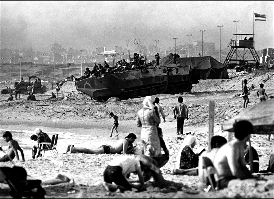 Busy Beach, US Marine Amtrac sits on "Green Beach" at the edge of Marine base at Beirut aiport. Lebanese sunbathers, MEA jet comes in to land. : USMC in Beirut 1982-1983 : BILL FOLEY 