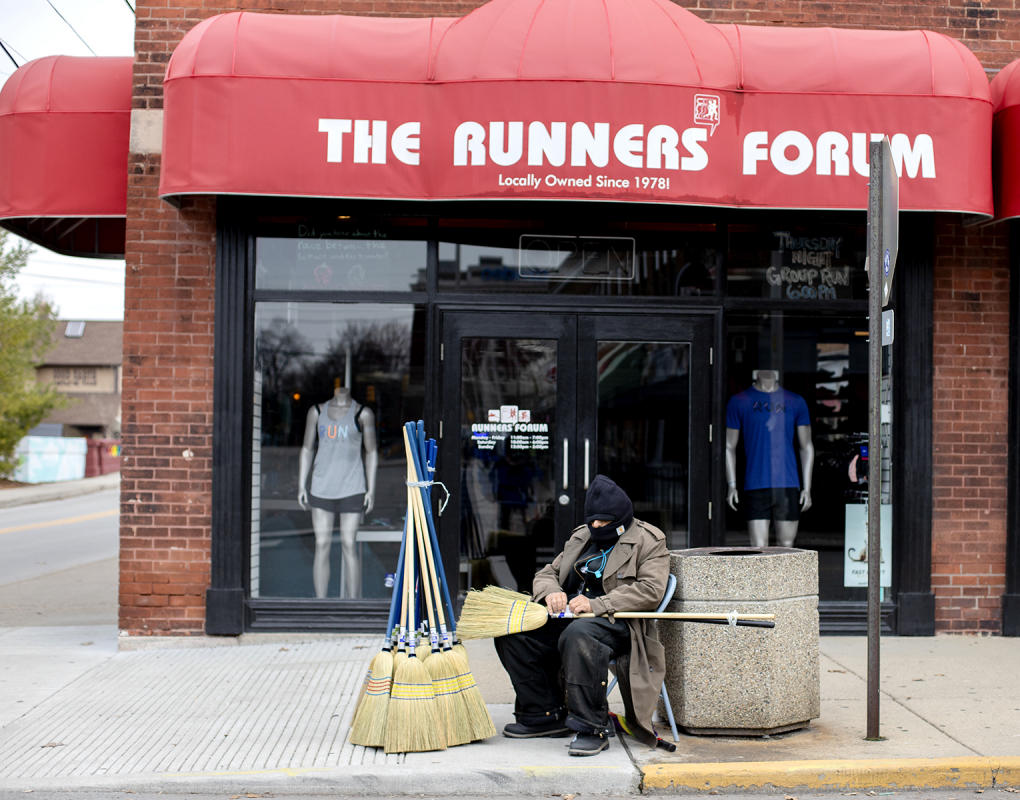 Jim the "Broom Guy" stays warm as he waits for customers. : Observations in a Pandemic 2020-2021 : BILL FOLEY 